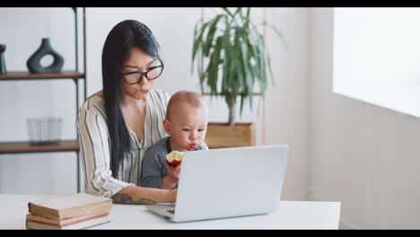working mom with baby at laptop