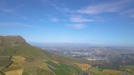 High-angle-drone-shot-of-Stellenbosch,-South-Africa-in-distance