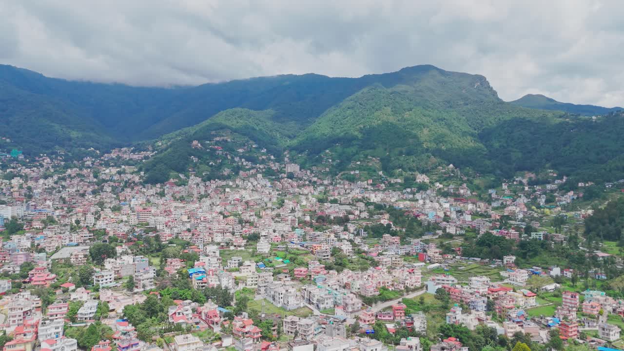 Aerial drone footage of Budhanilkantha in Kathmandu Valley, Nepal, showcasing city settlements, green hills, and scenic mountain landscapes from above
