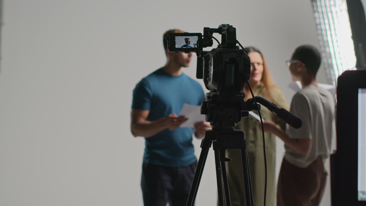 Female Film Director Talking With Male And Female Actors Holding Scripts Rehearsing For Shooting Movie Or Video In Studio 5