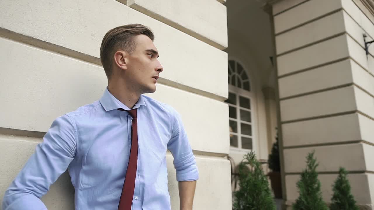Man in Business Attire Standing by Building