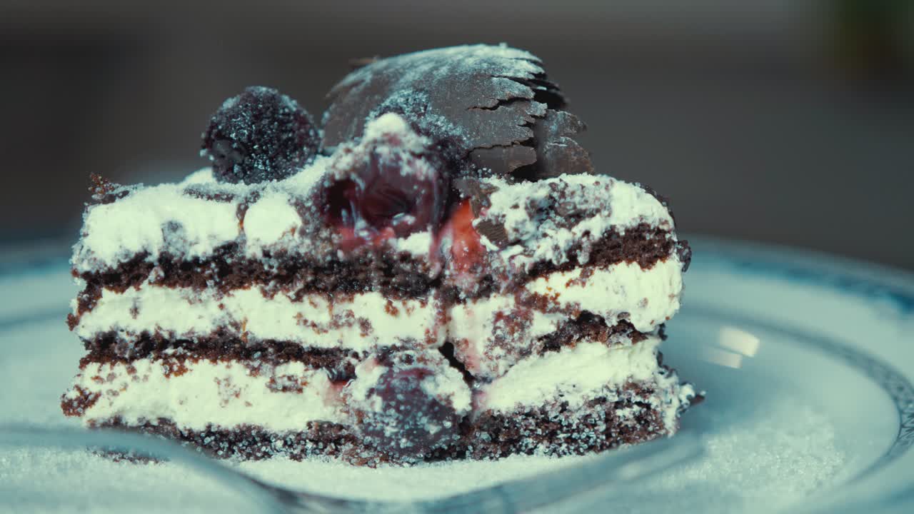 알갱이 설탕이 회전하는 식욕을 돋우는 초콜릿 크림 케이크 위에 떨어집니다.