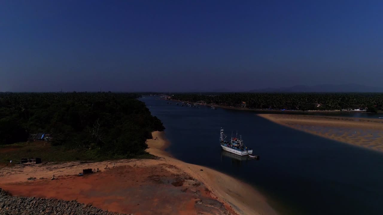 imágenes de drones que se mueven hacia abajo y hacia adelante hacia un barco de pesca anclado en un remanso