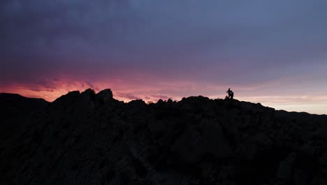 silhouette of people on a mountaintop at sunset