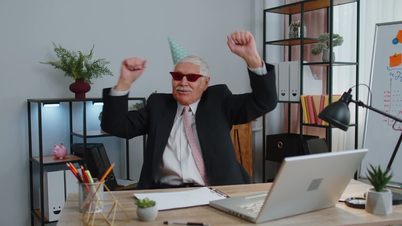 Uomo d'affari senior felice che balla per la vittoria, celebrando il successo del fine settimana e delle vacanze in ufficio