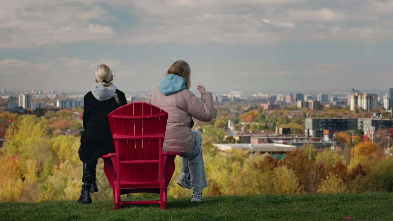 People Sitting on Red Chairs Overlooking City
