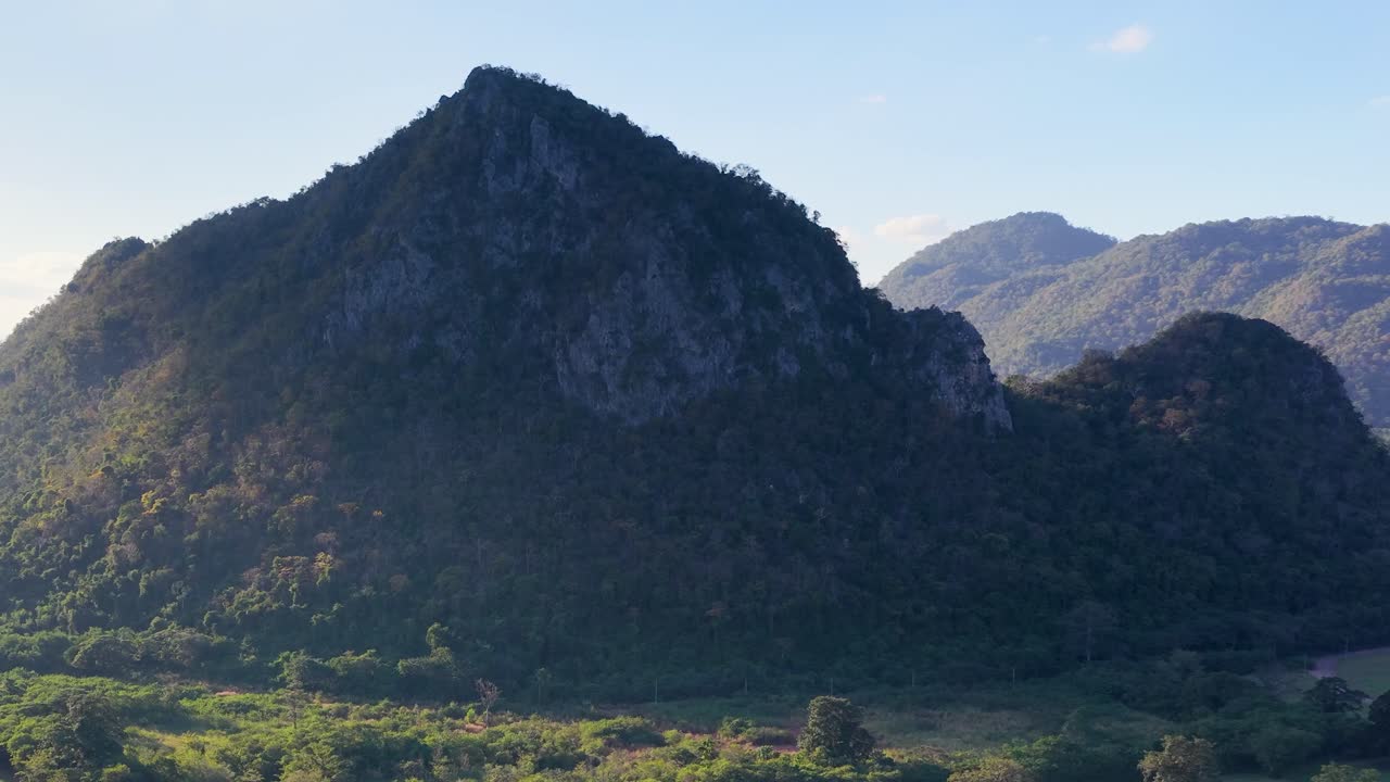 Rekaman drone menangkap hutan tropis yang rimbun dan pegunungan kapur di bawah langit biru yang cerah