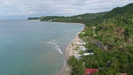 nice aerial view of beautiful beaches, natural view of the nature seascape, calm sea, cloudy sky, tall green mountains from the island of puerto galera, philippines