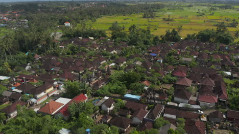 Low-flying-aerial-shot-over-the-rooftops-of-the-houses-in-a-dense-residential-neighborhood-in-Bali,-Indonesia