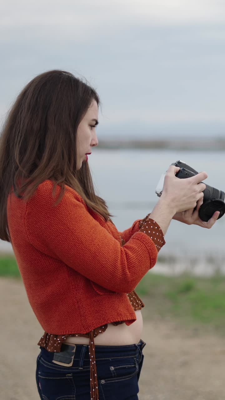 Donna che scatta foto al lago