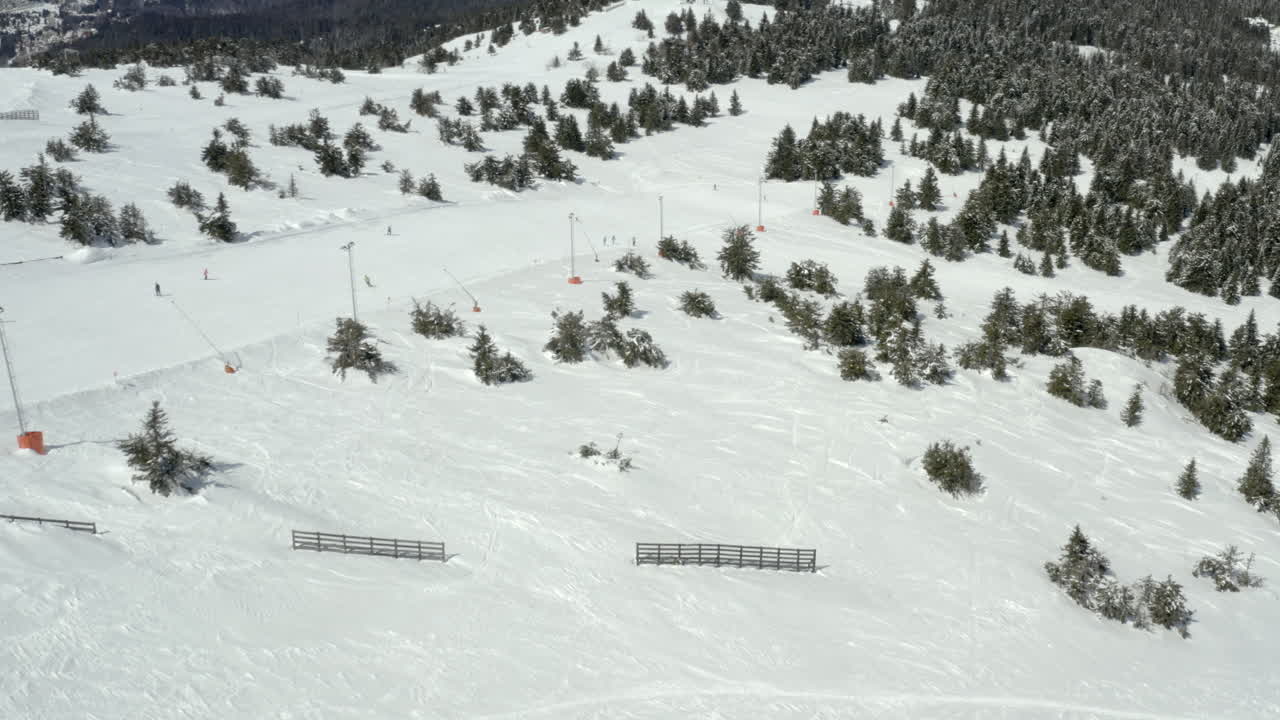 A high-angle view of a snowy ski resort with slopes and ski lifts
