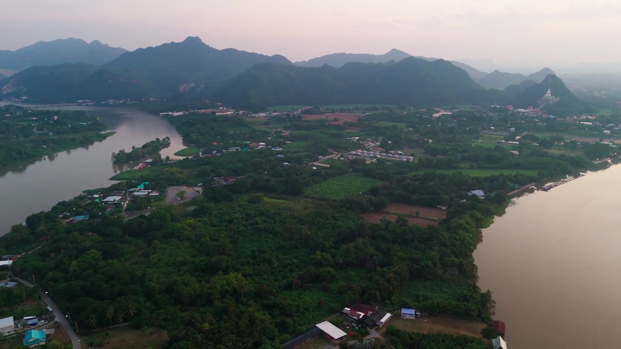 Vue aérienne au coucher du soleil de Kanchanaburi, Rivière Kwai, par drone, au-dessus d'un village thaïlandais, d'une montagne et d'une rizière, destination de voyage pittoresque