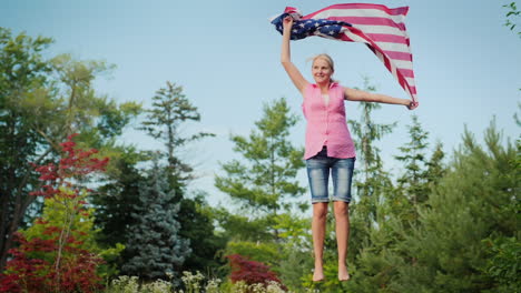 attractive woman with the us flag jumping on a trampoline in her backyard independence day and a tri