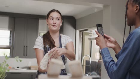 diversas amigas adolescentes felices y usando el teléfono inteligente en cámara lenta