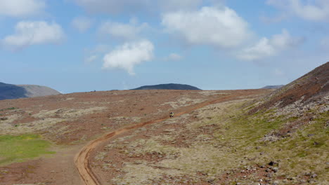 Vogelperspektive-Des-Mannes,-Der-Motocross-Auf-Wüstengrönland-In-Island-Tut.-Luftdrohnenansicht-Des-Fahrers,-Der-Motorrad-Offroad-Zwischen-Bergen-Fährt