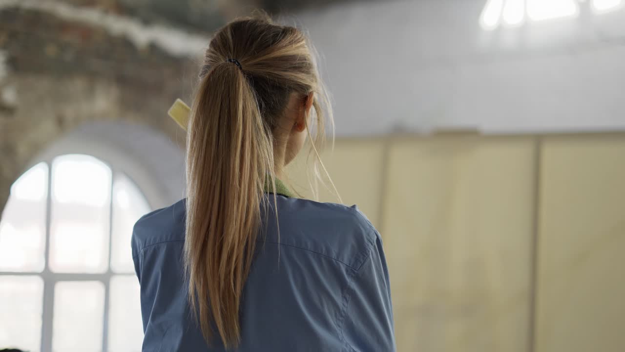 여성 예술가가 워크 ⁇ 에서 그녀의 예술 작품을 앞에서 반영하고, 개요