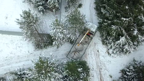 truck carrying concrete pipes in a snowy forest