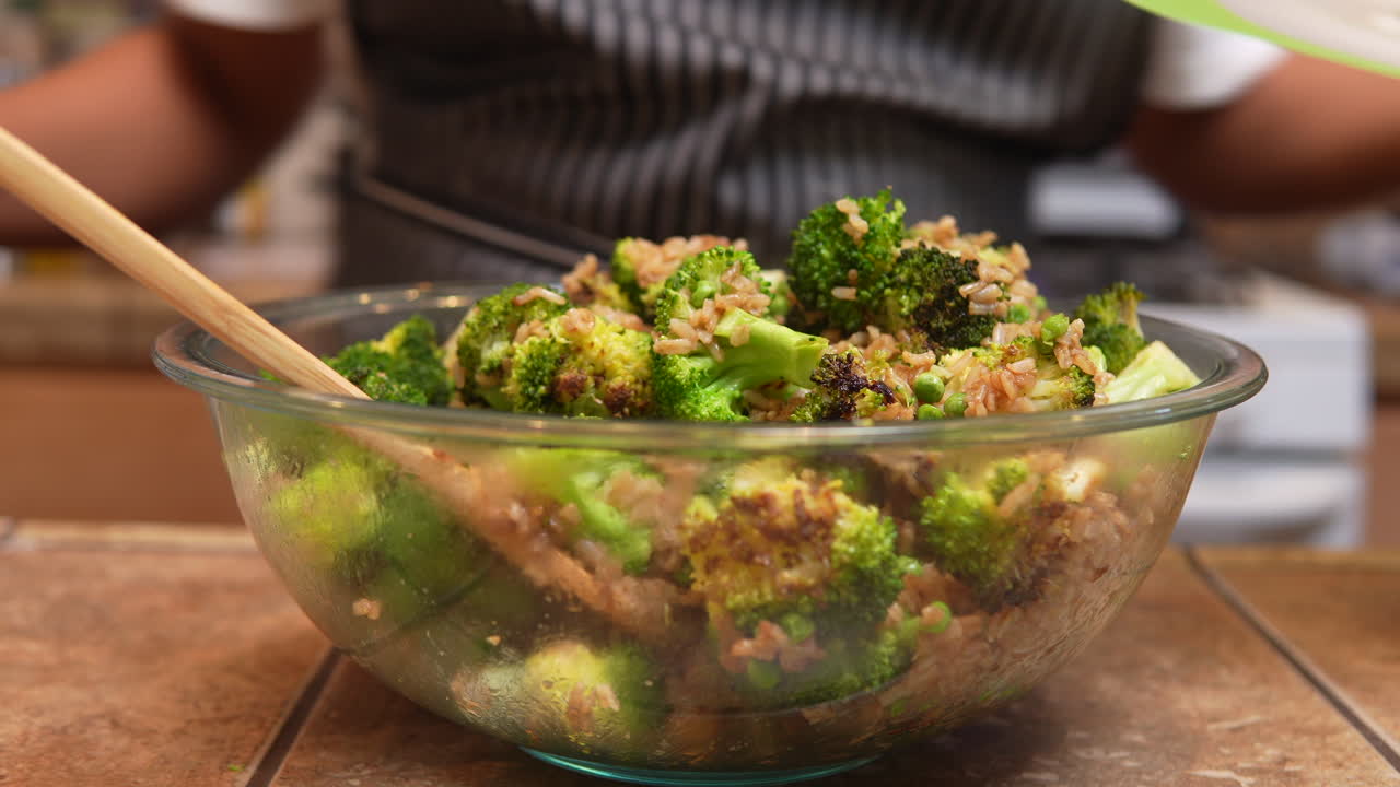 revolviendo cebollas verdes o cebolletas en un plato de brócoli recién frito y humeante con otros ingredientes