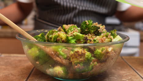 Stirring green onions or scallions into a freshy fried and steaming broccoli dish with other ingredients