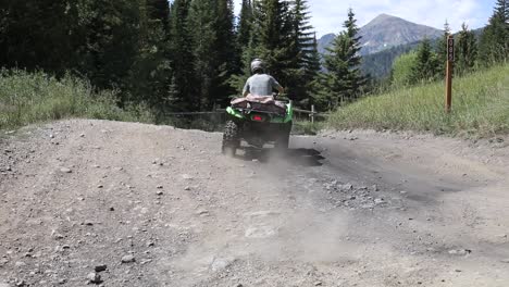 shot of an atv rider driving his quad on a dirt path in the wasatch mountains