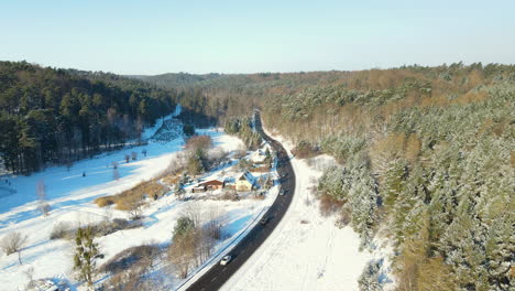 amazing winter poland landscape from the top, cars moving along the countryside road in a snow-covered forest in winter