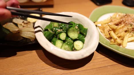 hands mixing vegetables in a bowl with chopsticks