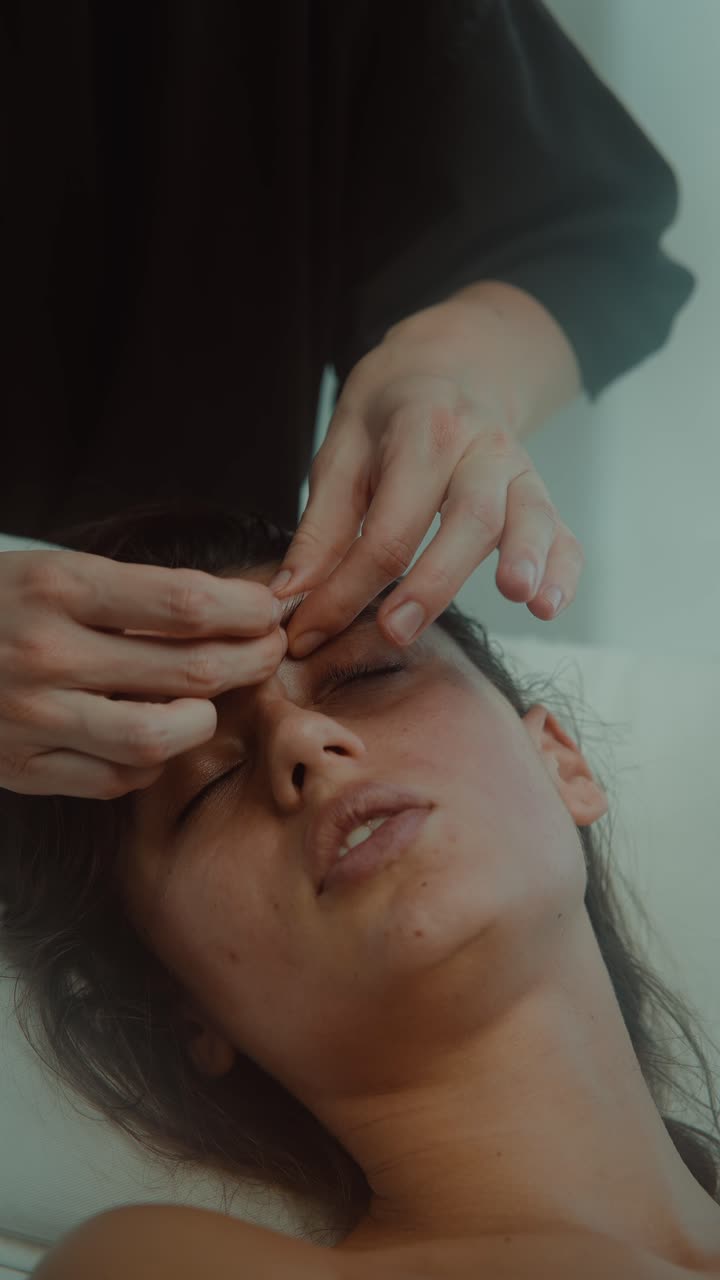 Nahaufnahme einer Frau, die eine entspannende Gesichtsmassage erhält.