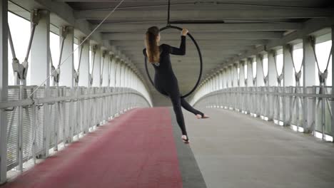 sexy young slim girl spinning in a hanging hoop. urban acrobatics