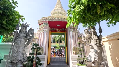 visitors entering wat pho through ornate gate