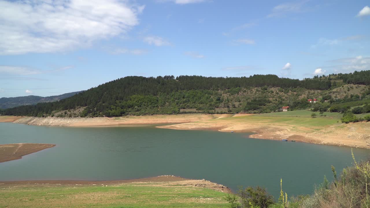 vista panorámica de un lago que se seca, presa en la montaña, calentamiento global, cambio climático