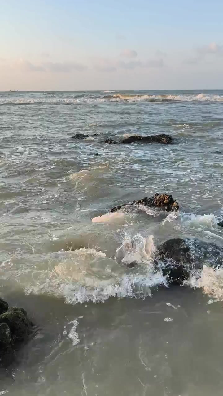 Dolci onde oceaniche che lambiscono rocce muschiose al tramonto