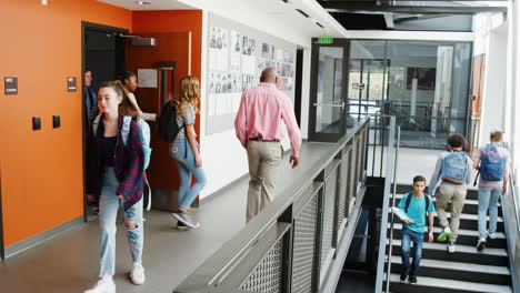 slow motion shot of busy high school corridor during recess with students and staff