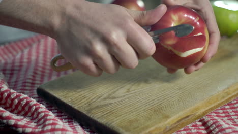 Process-cutting-peel-of-fresh-apple.-Preparing-diet-food.-Hands-cut-peel-apple