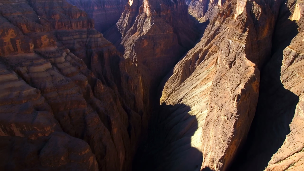 Aerial Sandstone Canyon Bathed In Golden Light, Cinematic Drone Sweep Reveals Deep Gorge And Layered Strata,