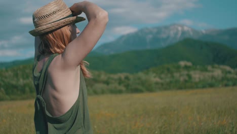 woman with hat looking to mountains