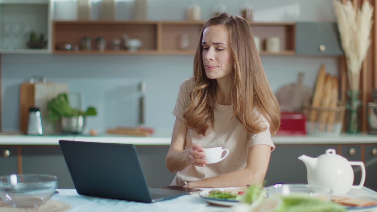 mujer trabajando en una computadora portátil en la cocina