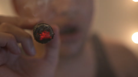 close up of a young man smoking a cigar