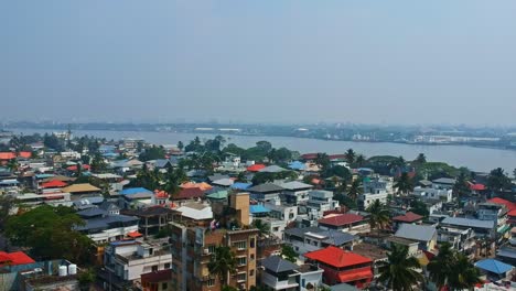 Vista-Aérea-De-La-Ciudad-De-Kochi-Desde-El-Fuerte-Kochi-,-Un-Lago-Que-Fluye-Por-El-Centro-De-La-Ciudad-De-Kochi-,-Vista-Aérea-De-Las-Casas-De-La-Ciudad-Abarrotadas