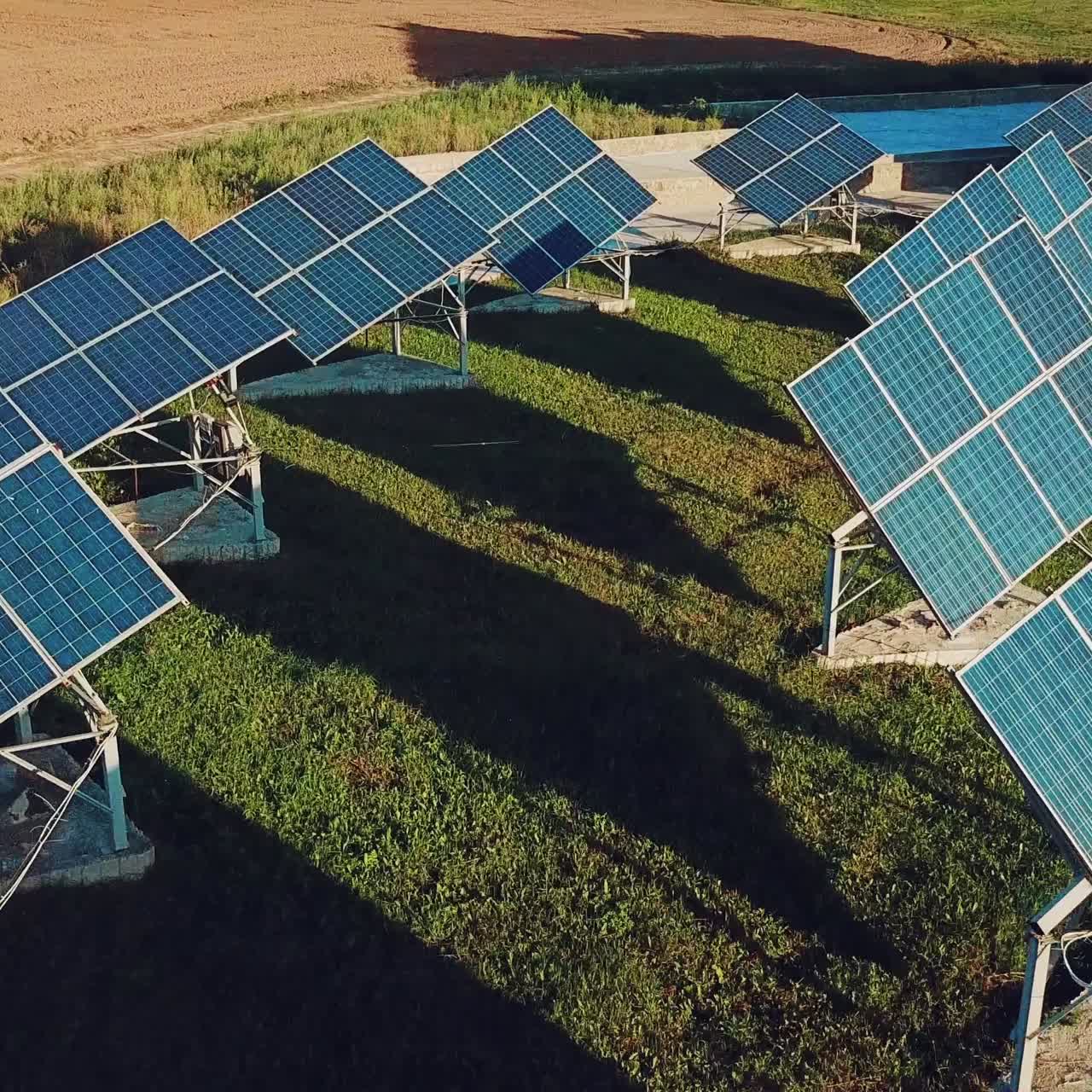 view of two rows of solar panels on the background of green grass. Plant for the production of solar panels. Aerial view. Ecology.