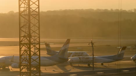 airplanes on the tarmac at sunset