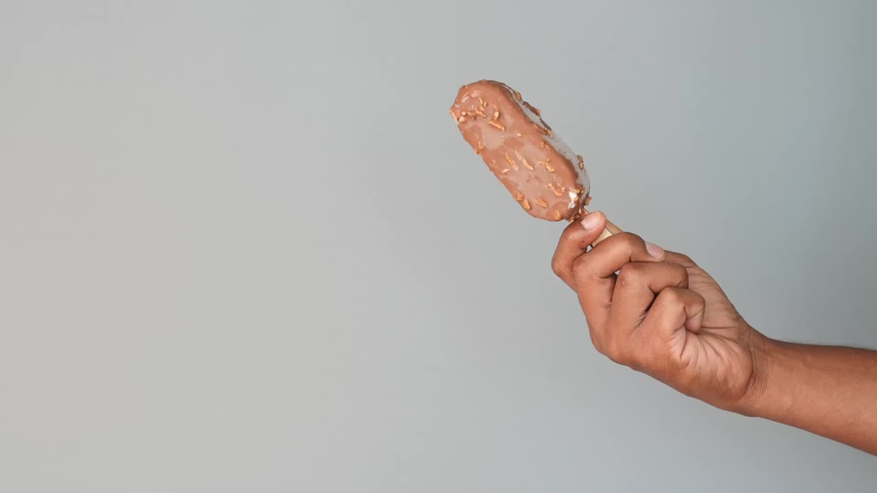 Hand holding a chocolate ice cream bar