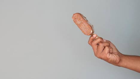 hand holding a chocolate ice cream bar