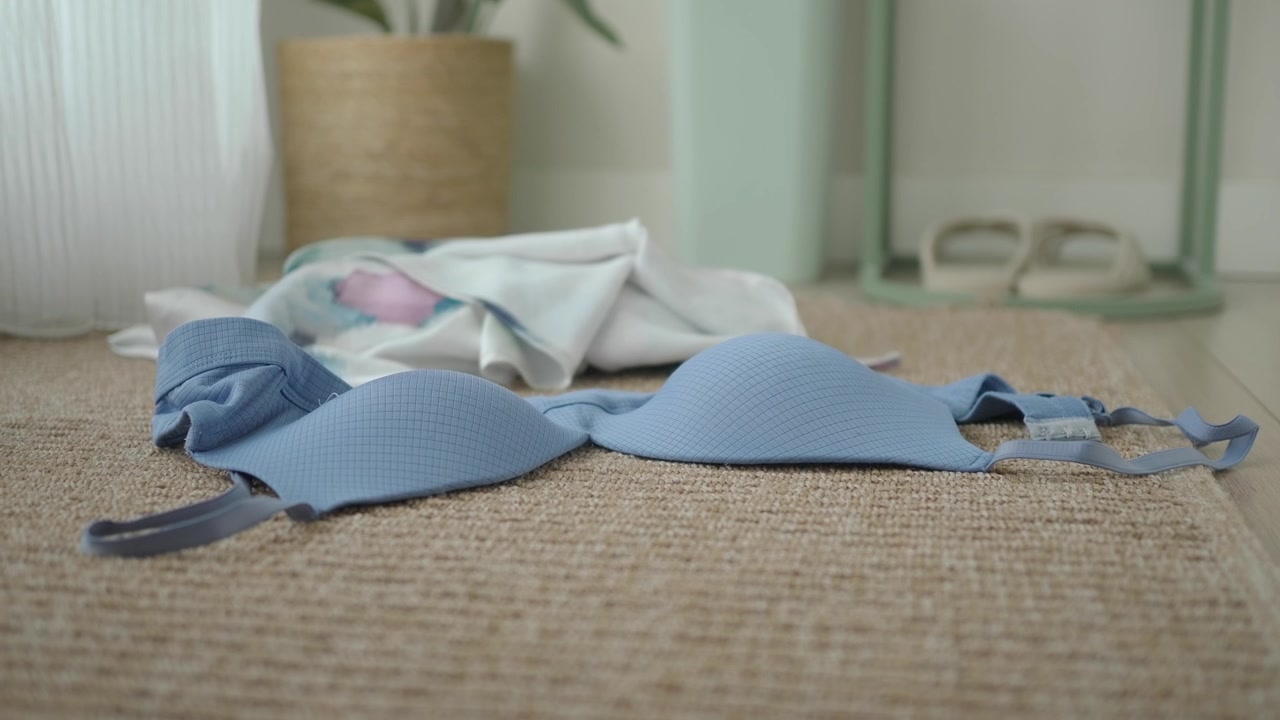 Light Blue Bra Lying on a Beige Carpet