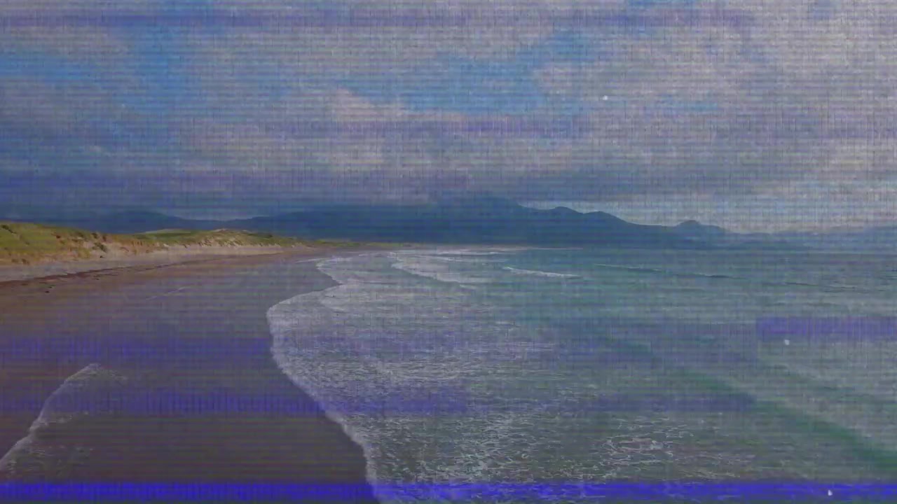 Flat design coastline showing breaking waves rolling onto sandy shore under cloudy mountain skyline