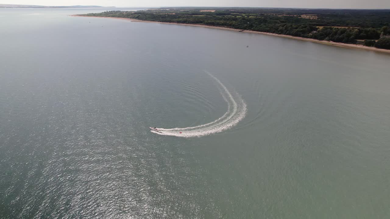 wakeboarder remolcado detrás de una lancha a motor - wakeboarding en el estrecho de solent cerca de calshot, reino unido