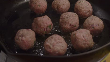 Adding-meat-balls-into-hot-frying-pan-with-boiling-cooking-oil