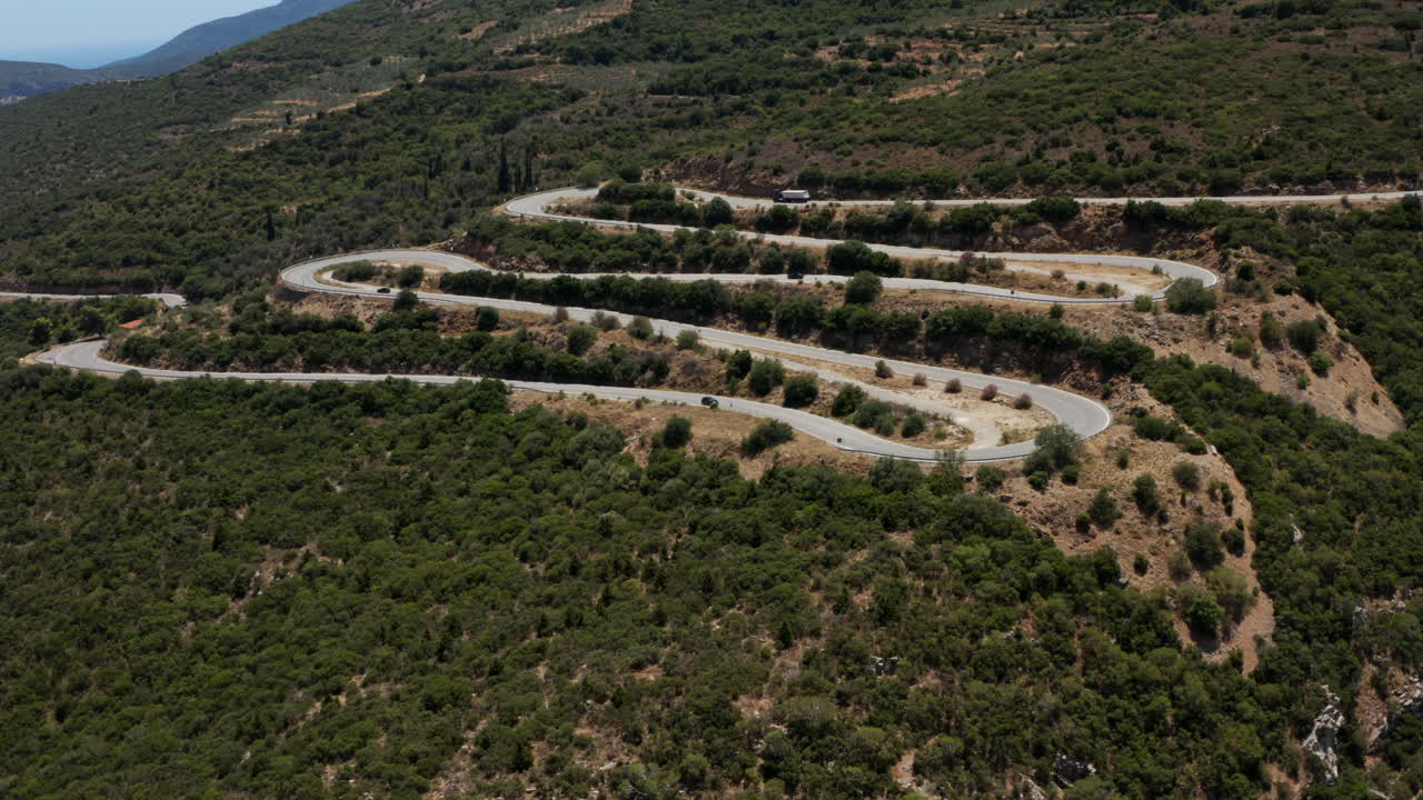 vista aérea de los vehículos que conducen por un camino sinuoso junto a la montaña en el peloponeso, grecia