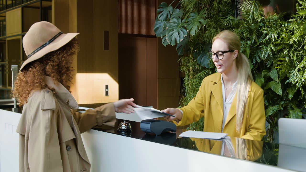 рыжеволосая женщина-гость, несущая чемодан на прием