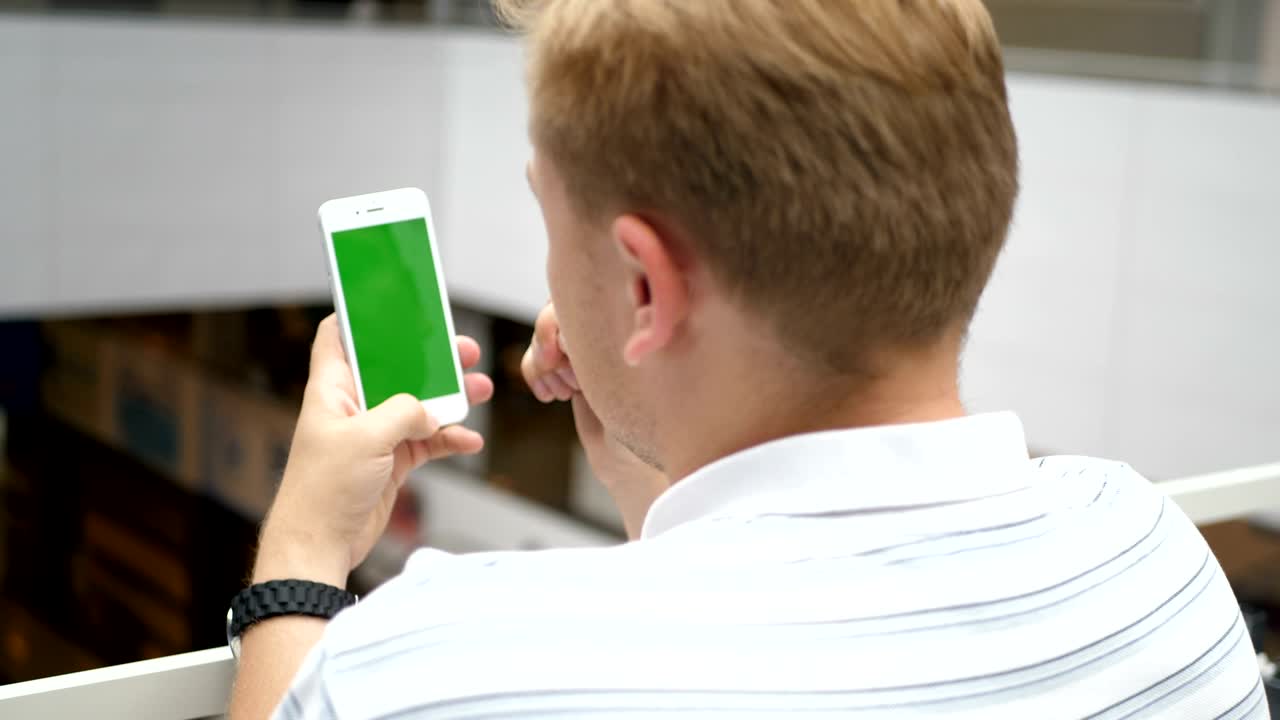 녹색 화면으로 휴대 전화를 사용하는 사람. 그래서 당신은 쉽게 품질을 잃지 않고, 크로프, 회전 및 을 할 수 있습니다. 추적 및 키를 위해 쉬운. 손으로 잡은 스마트 폰. 녹색 스크린 크로마 키. 근접. 수직.