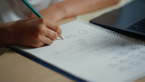 schoolboy writing in notebook indoors